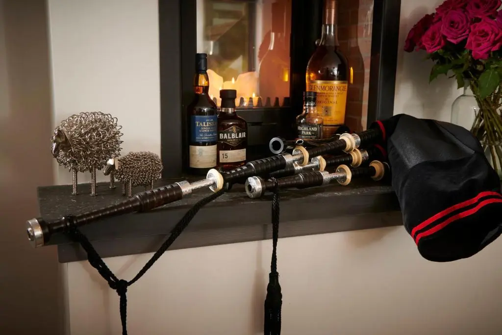 a shelf with bottles of alcohol on a wall at Ben Luna Lodge in Inverness