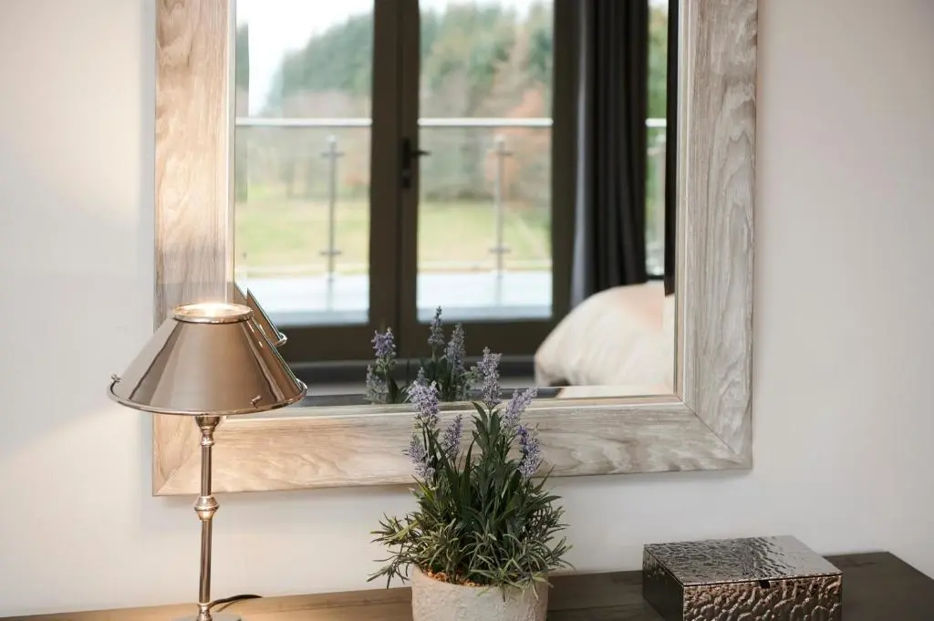 a lamp sitting on a table next to a mirror at Ben Luna Lodge in Inverness