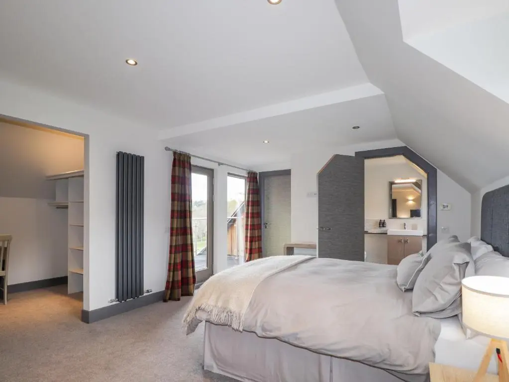 a bedroom with a large bed and a mirror at Ben Luna Lodge in Inverness