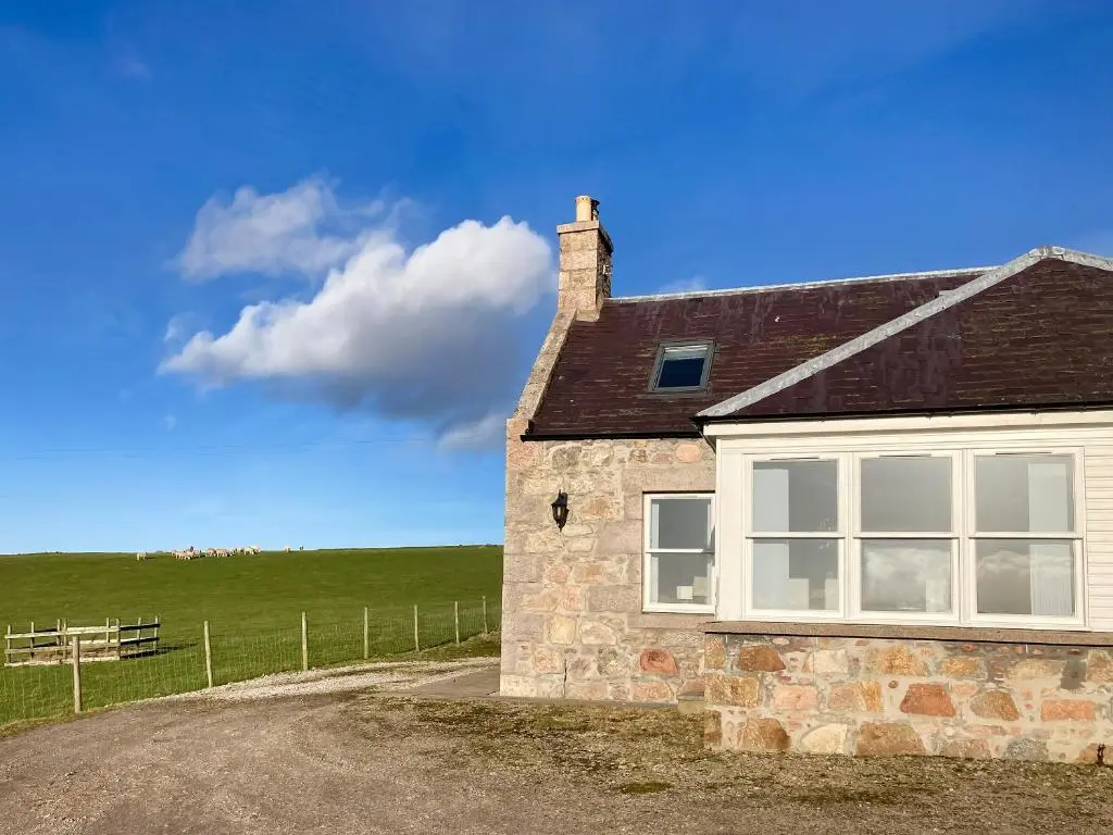 a stone house with a window and a field at Guise Cottage Uk46303 in Tough