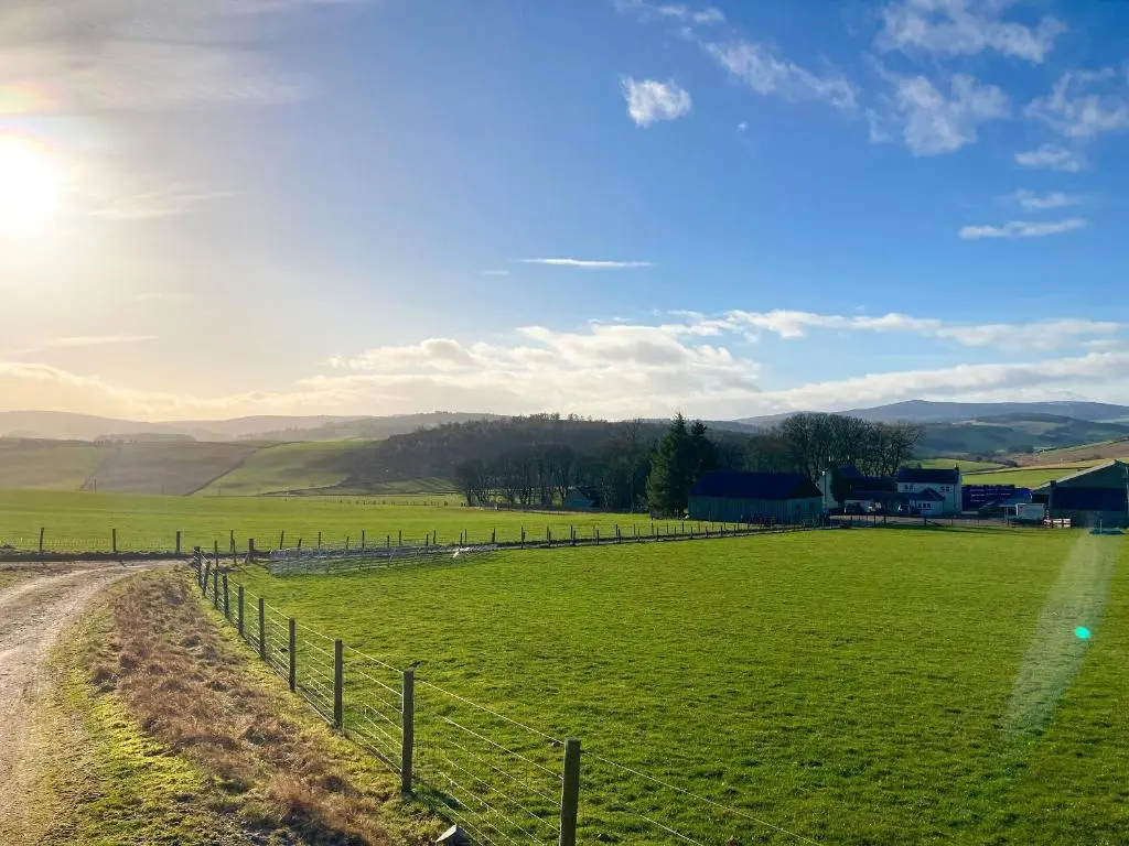 a field with a fence and a dirt road at Guise Cottage Uk46303 in Tough