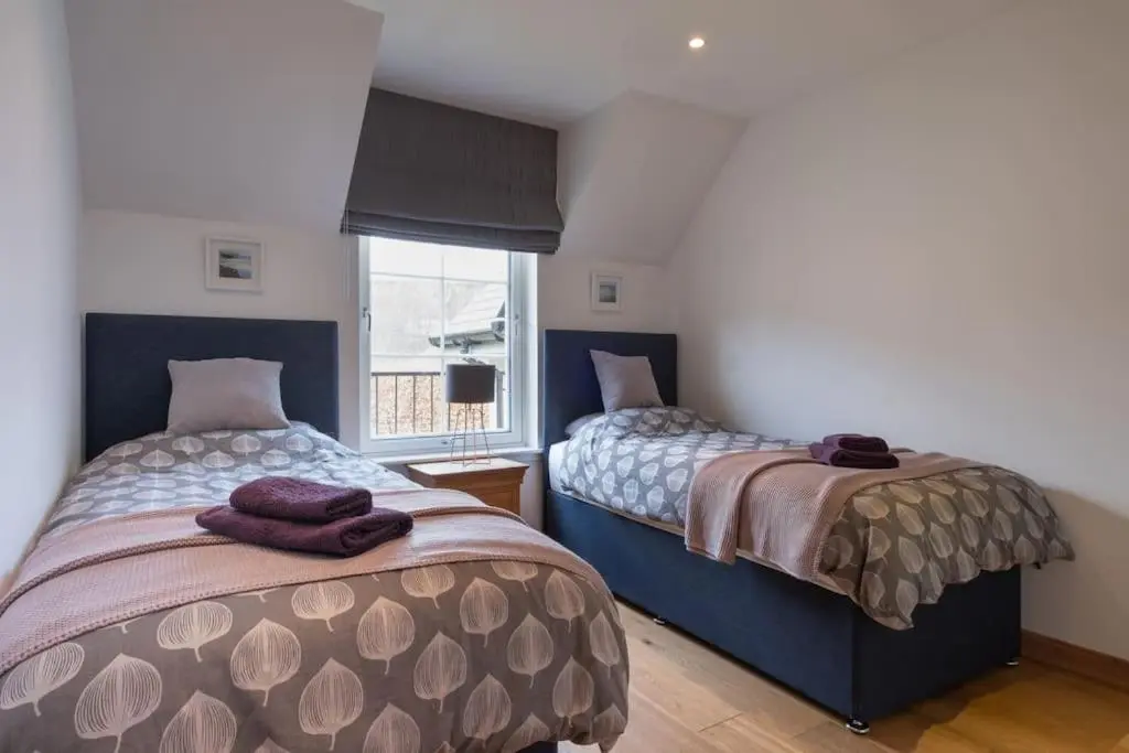 a bedroom with two beds and a window at The Steadings in Aviemore