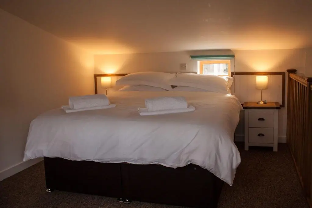 a large white bed with two white towels on it at Callater in Braemar