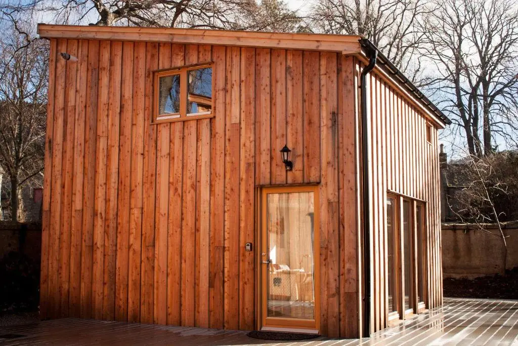 a wooden building with a door and a window at Choinnich in Braemar