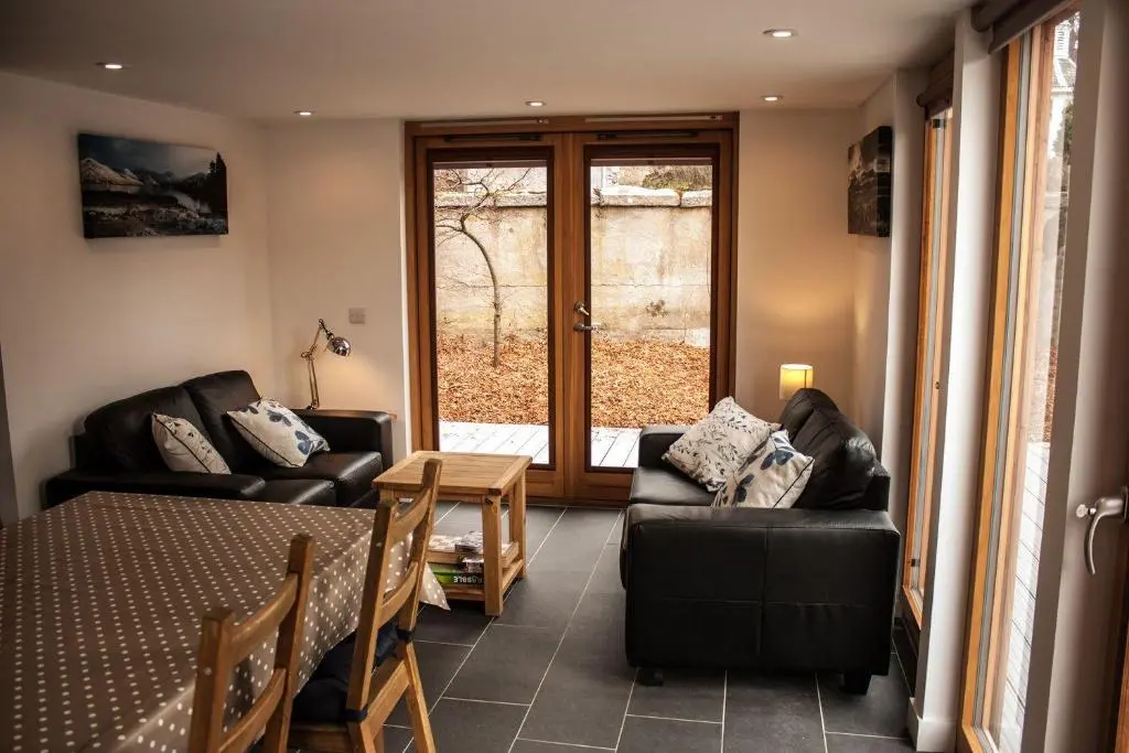 a living room with a couch and a table at Choinnich in Braemar
