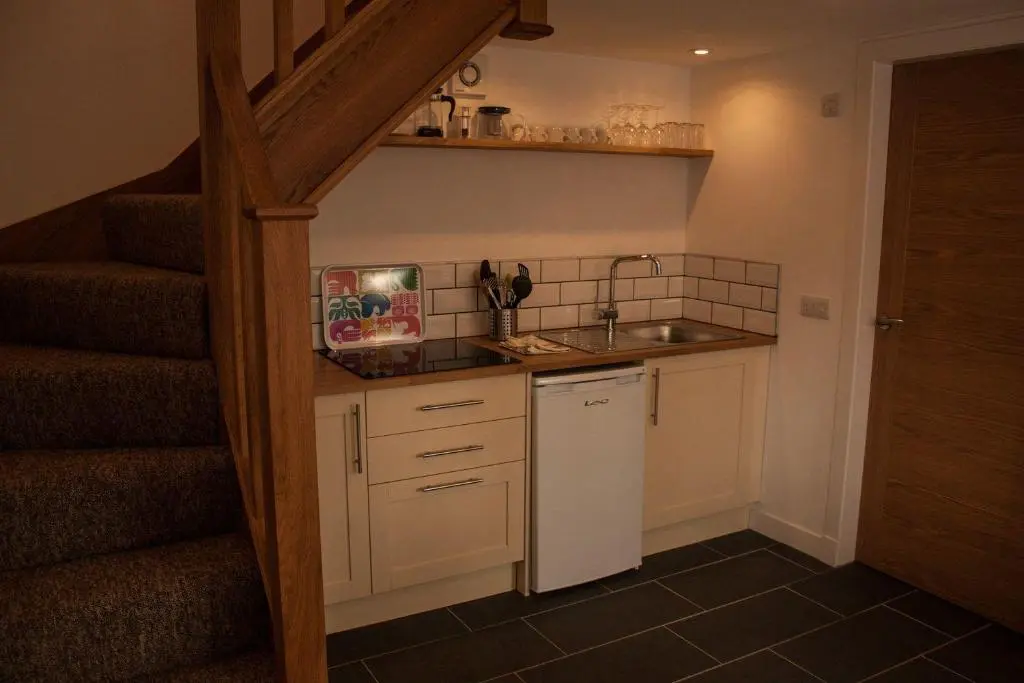 a small kitchen with a sink and a staircase at Choinnich in Braemar