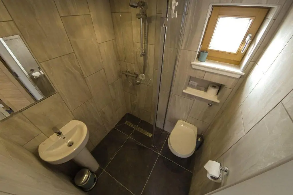 a bathroom with a sink and a toilet and a window at Clunie in Braemar