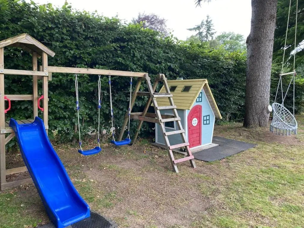 a playground with a slide and a play house at Langdale Lodge in Inverness