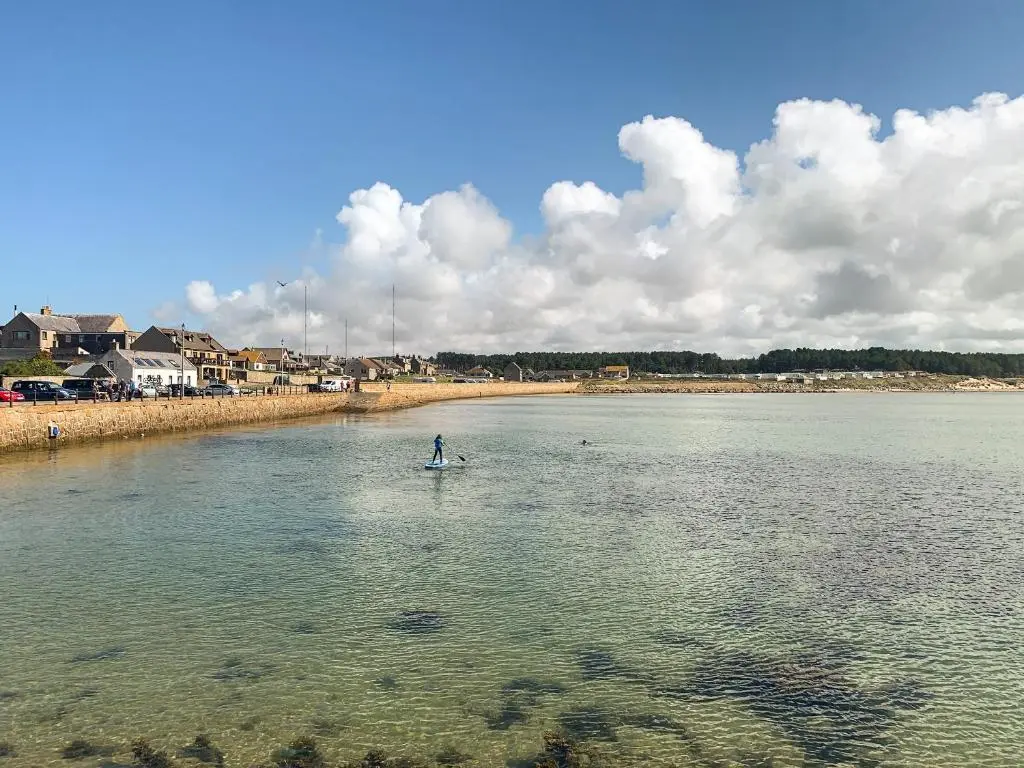 a person on a paddle board in the water at Emerald Cottage in Burghead