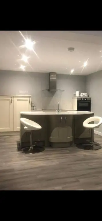 a kitchen with a counter and two stools in it at Lisbon 67 in Wick