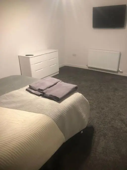 a bedroom with a bed with a dresser and a tv at Lisbon 67 in Wick