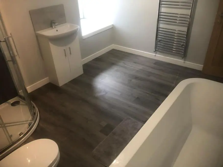 a bathroom with a toilet and a tub and a sink at Lisbon 67 in Wick