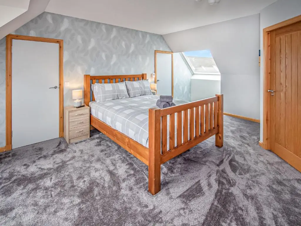 a bedroom with a bed and a refrigerator at Beinn View House in Cononbridge