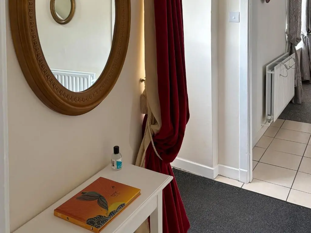 a mirror sitting on the wall next to a table at Ivydene Cottage in Cromarty