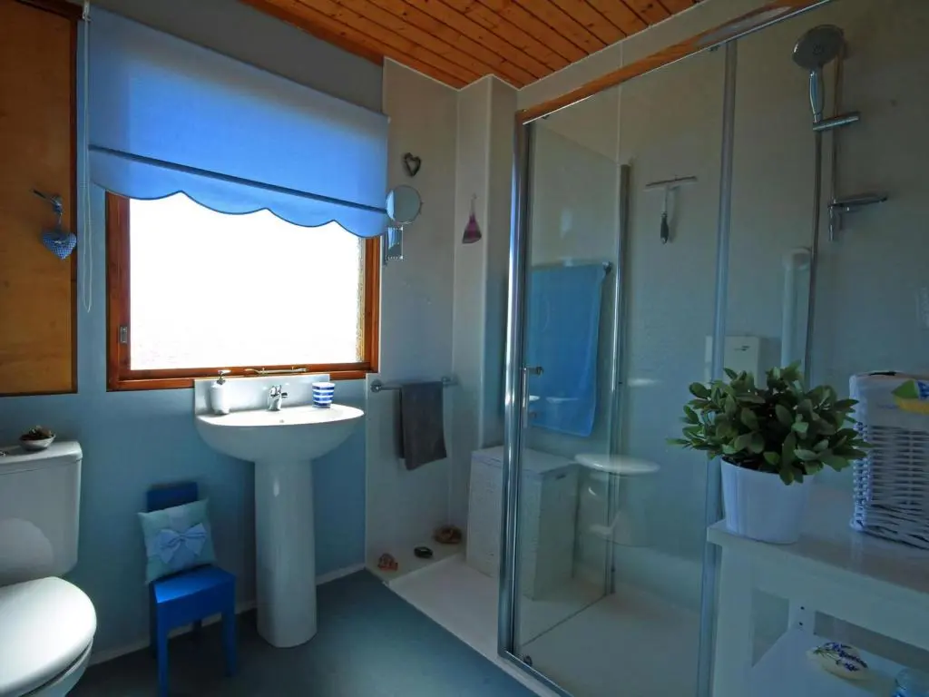 a bathroom with a sink and a shower and a toilet at Achnacarry Cottage in Evelix