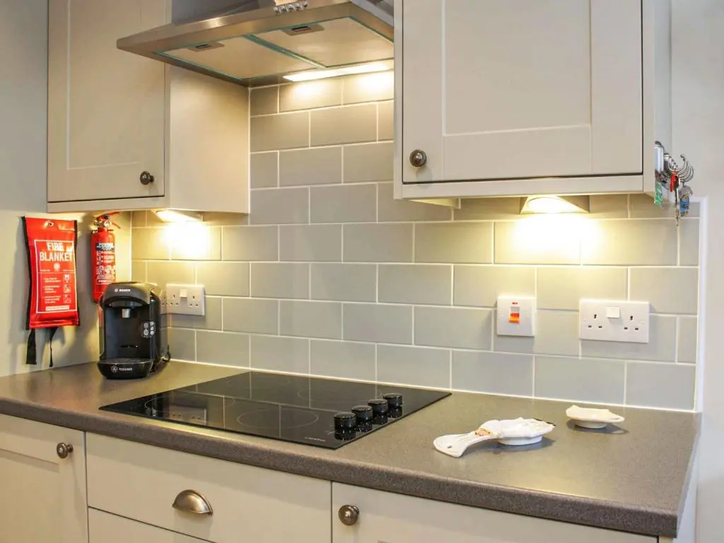 a kitchen with a stove top and white cabinets at Apartment 8 The Granary-Uk7466 in Banff