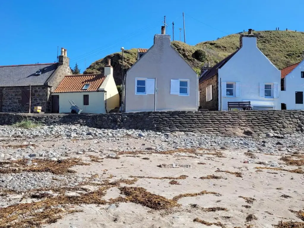 a group of houses on a rocky beach at Crovie Cottage in Gardenstown