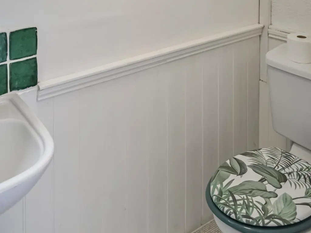 a bathroom with a toilet with a plant bowl on it at Douneside Cottage in Inverness