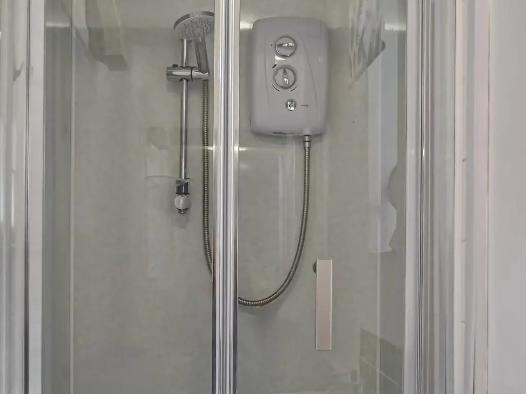 a shower with a shower head in a shower at Douneside Cottage in Inverness