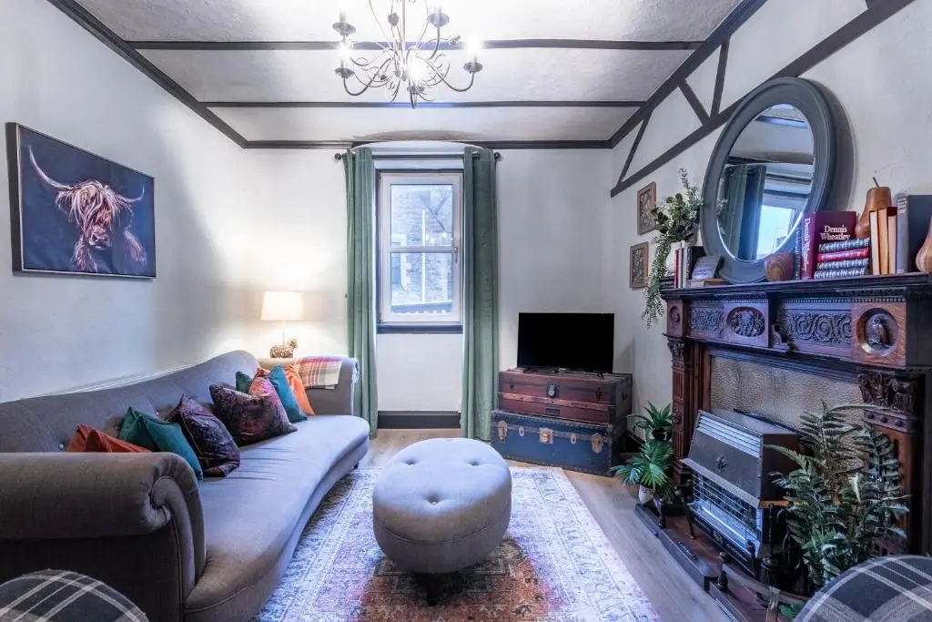 a living room with a couch and a mirror at Criss Cross Cottage in Inverness