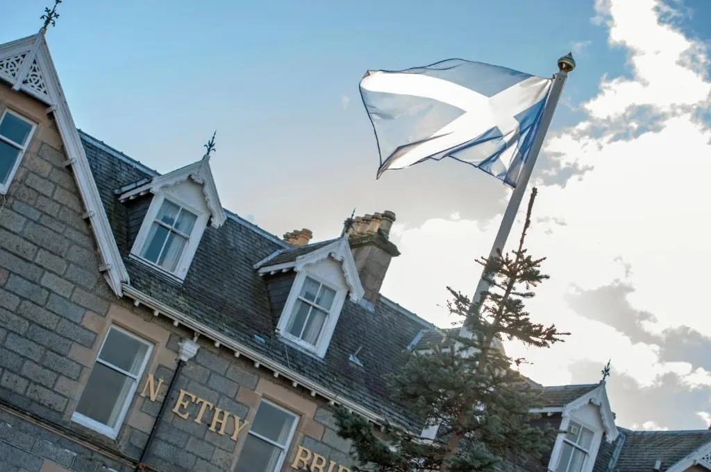 a flag flying in front of a house at Nethybridge Hotel in Nethy Bridge