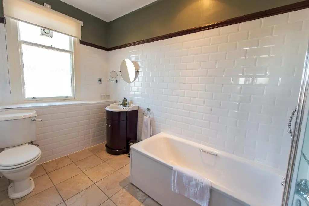 a bathroom with a tub and a toilet and a sink at Nethybridge Hotel in Nethy Bridge