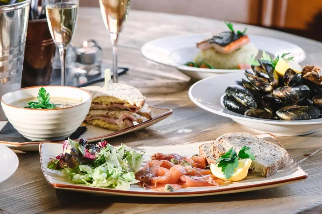 a wooden table with plates of food on it at Boat Country Inn and Restaurant in Boat of Garten