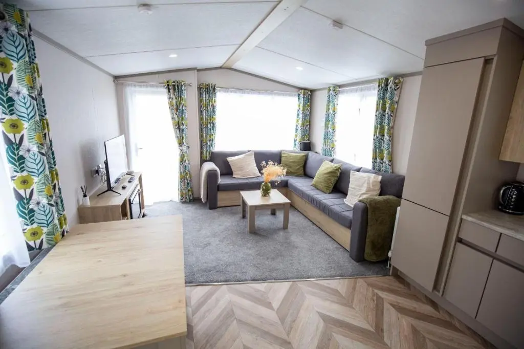 a living room with a couch and a table at Grantown Get Away - SJA Stays - Modern 2 Bed Static in Grantown on Spey