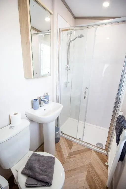a bathroom with a shower and a toilet and a sink at Grantown Get Away - SJA Stays - Modern 2 Bed Static in Grantown on Spey