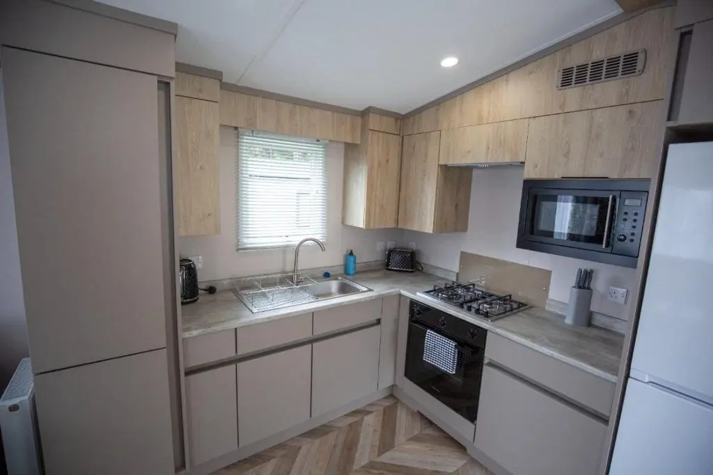 a kitchen with a sink and a stove top oven at Grantown Get Away - SJA Stays - Modern 2 Bed Static in Grantown on Spey
