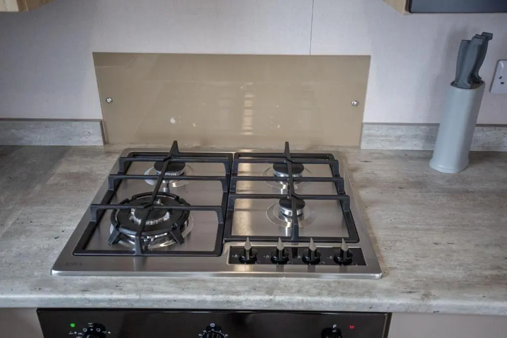a stove top with three burners on a kitchen counter at Grantown Get Away - SJA Stays - Modern 2 Bed Static in Grantown on Spey