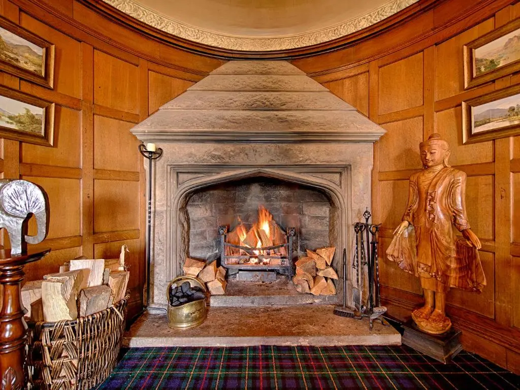 a fireplace in a room with a statue in front of it at Kincraig Castle Hotel in Invergordon
