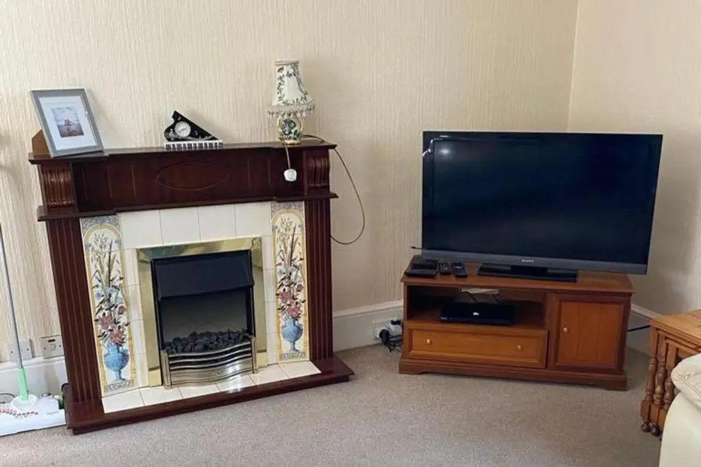 a living room with a fireplace and a flat screen tv at 2 Bed Cottage Sleeps 4-Pets Welcome-Private Garden in Buckie