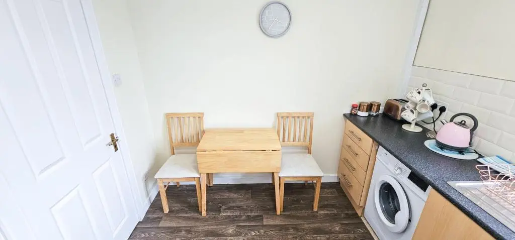 a kitchen with a table and chairs and a washing machine at 1 Bedroom House - Inverness - River Canal in Inverness