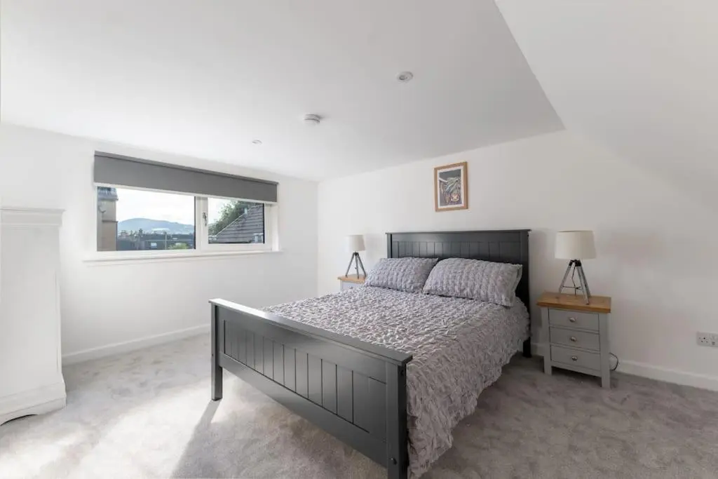 a bedroom with a large bed and a window at Town centre flat in Inverness