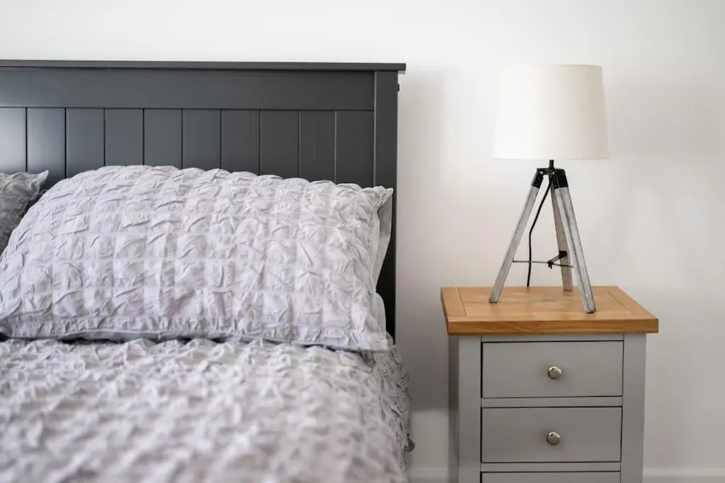 a bedroom with a bed with a lamp on a night stand at Town centre flat in Inverness