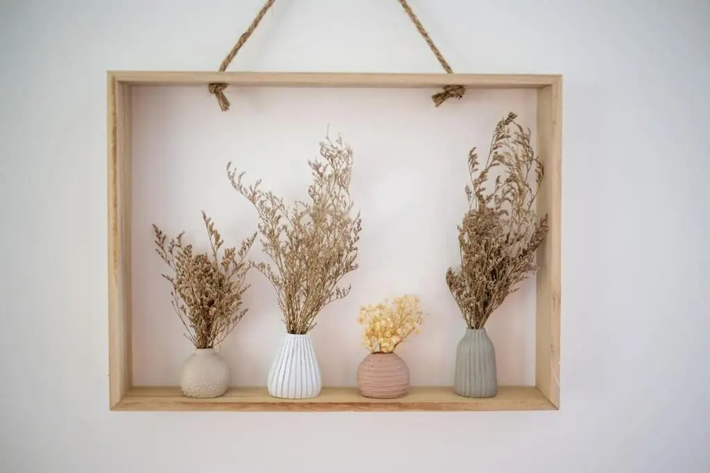 four vases on a shelf with flowers in them at Town centre flat in Inverness