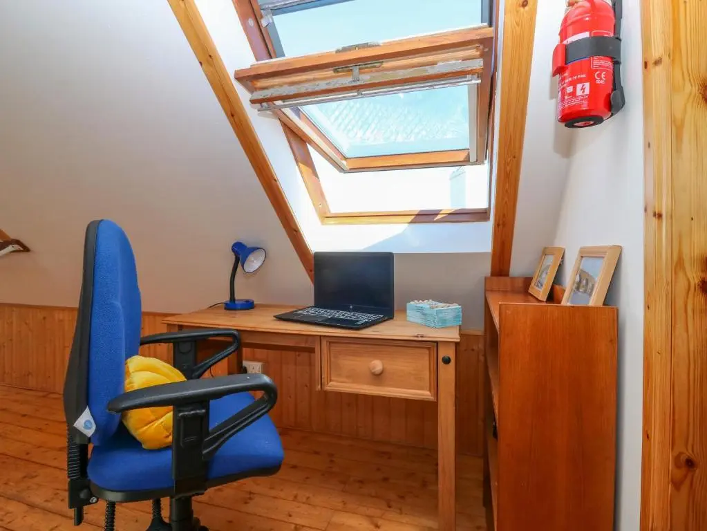 a room with a desk with a computer and a window at Jade Cottage in Macduff