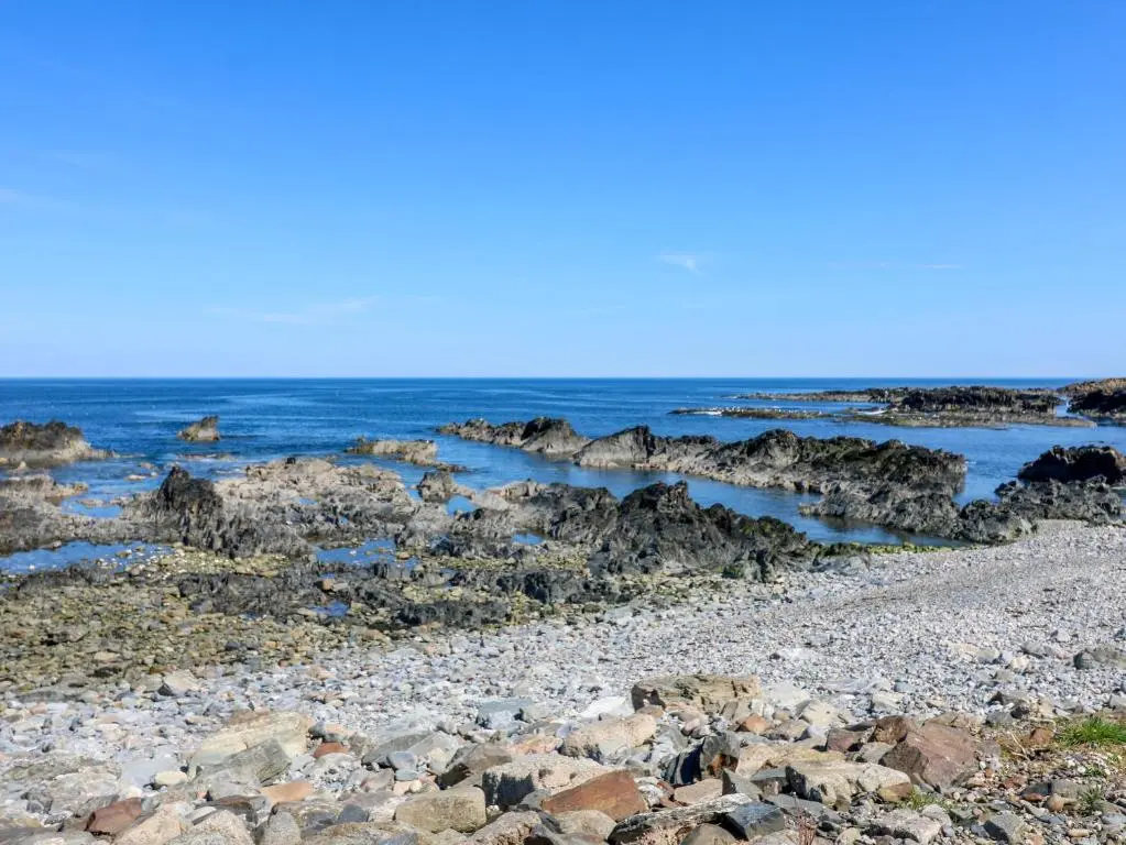 a rocky beach with rocks and the ocean at Jade Cottage in Macduff