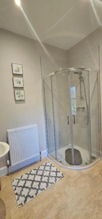 a shower stall in a room with a rug at Balmore Farmhouse near Lochness in Inverness