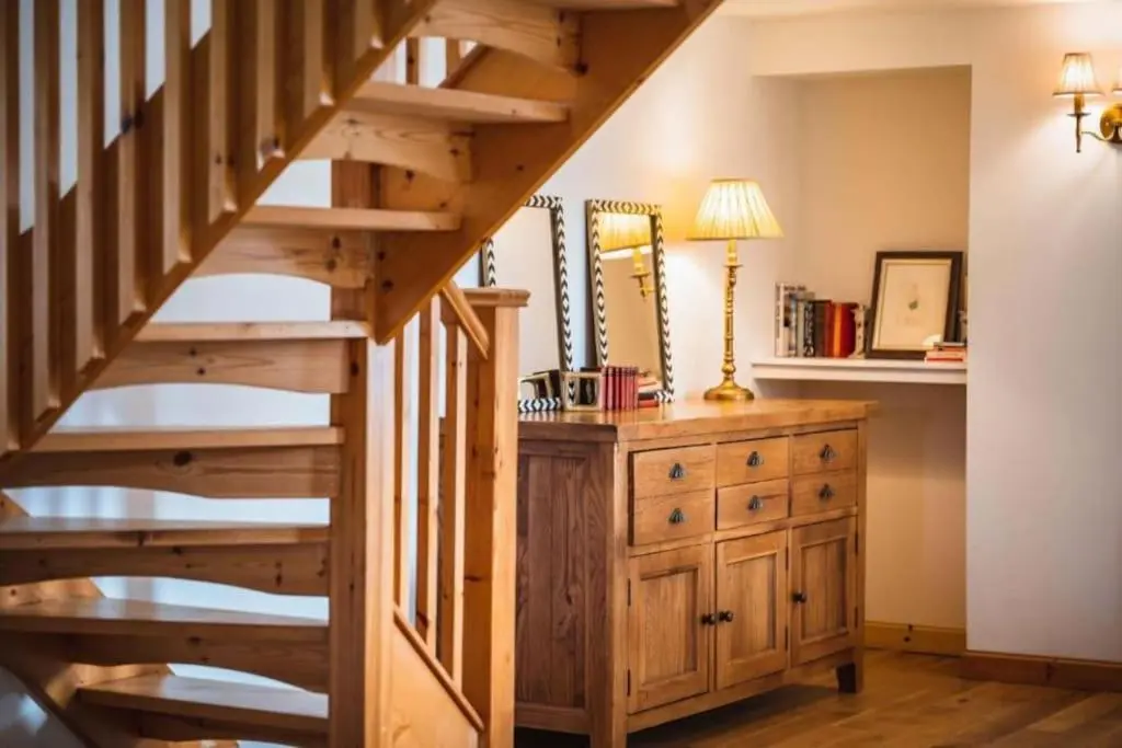 a wooden staircase in a room with a wooden dresser at Grieves Cottage, near Dornoch in Dornoch