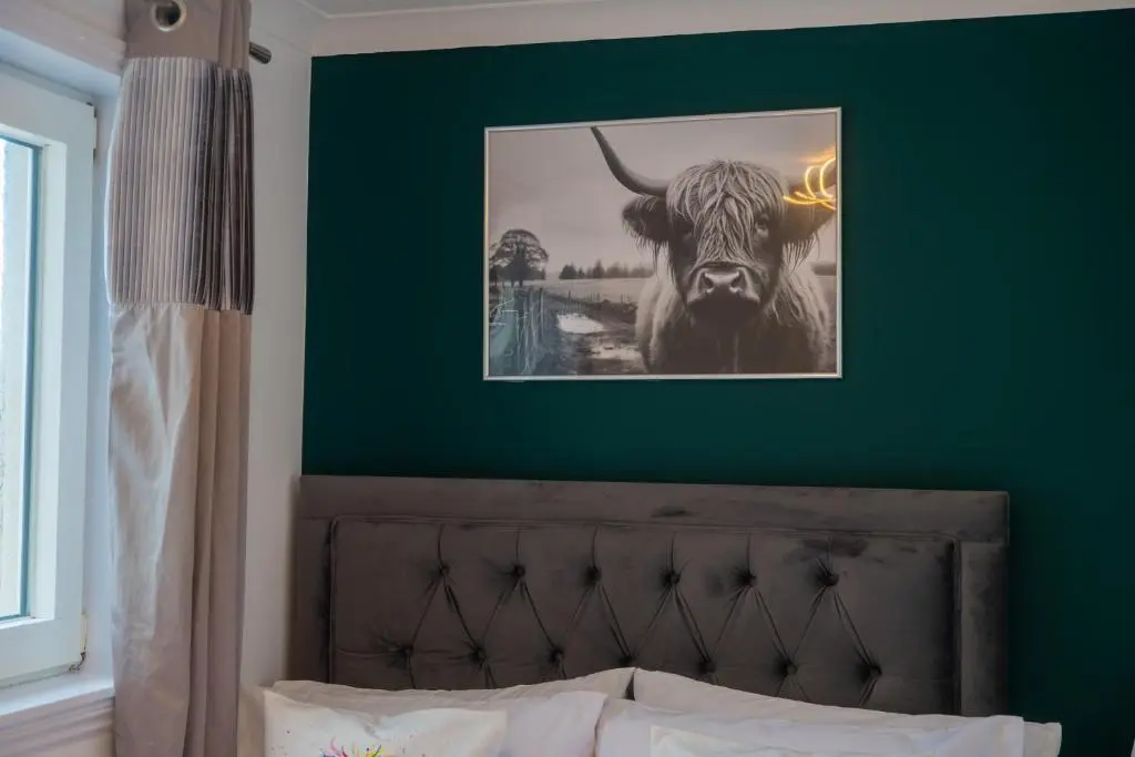a picture of a cow on a green wall at Two Bedroom Hilton Apartment 1st floor in Inverness