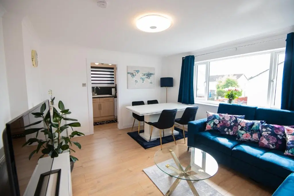 a living room with a blue couch and a table at Two Bedroom Hilton Apartment 1st floor in Inverness