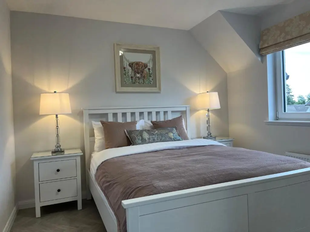 a bedroom with a large bed with two night stands at The Beech House in Aviemore