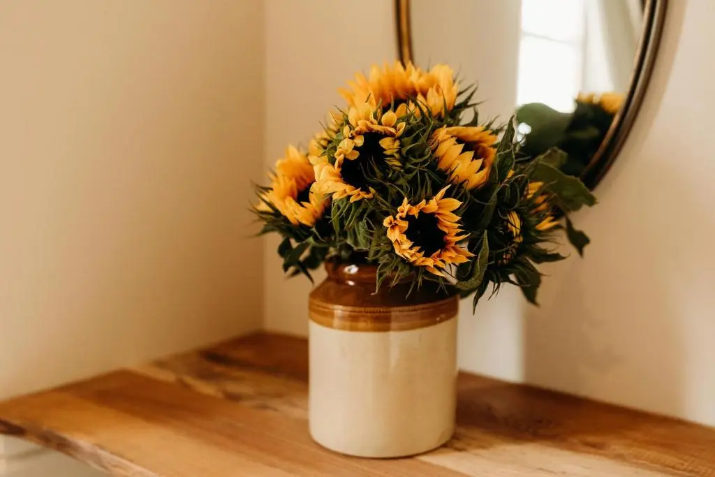 a vase filled with sunflowers sitting on a table at No1 Burgie Mains Cottage in Forres
