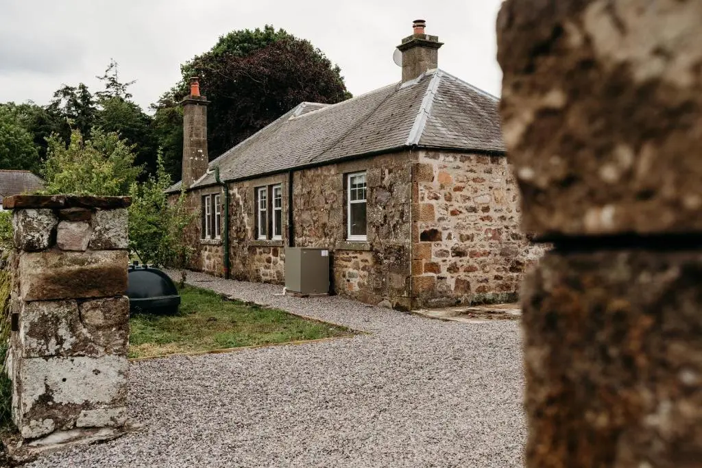 an old stone house with a driveway in front of it at No1 Burgie Mains Cottage in Forres