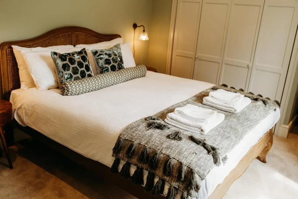 a bedroom with a bed with a blanket and pillows at No1 Burgie Mains Cottage in Forres