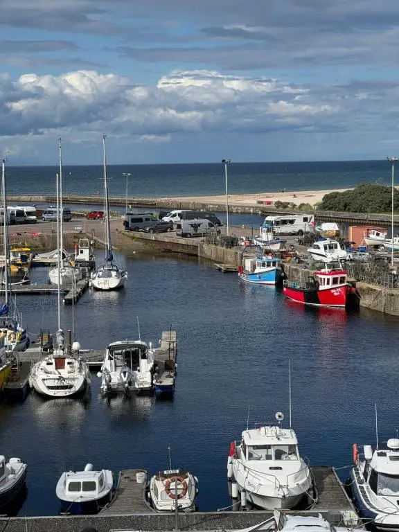 a bunch of boats are docked in a harbor at The Lighthouse in Nairn