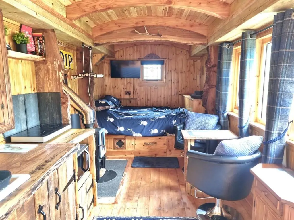 a living room with a bed in a tiny house at The Shepherds Neuk in Inverness