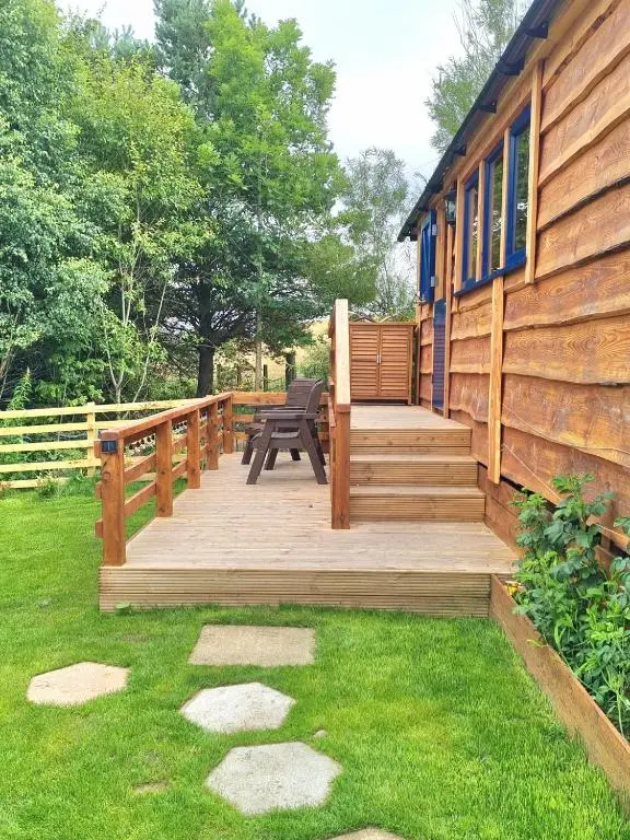 a wooden deck with a bench on a house at The Shepherds Neuk in Inverness